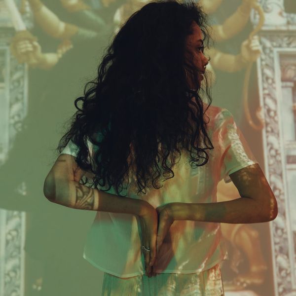Woman in a peaceful meditation pose, symbolizing creative thought.